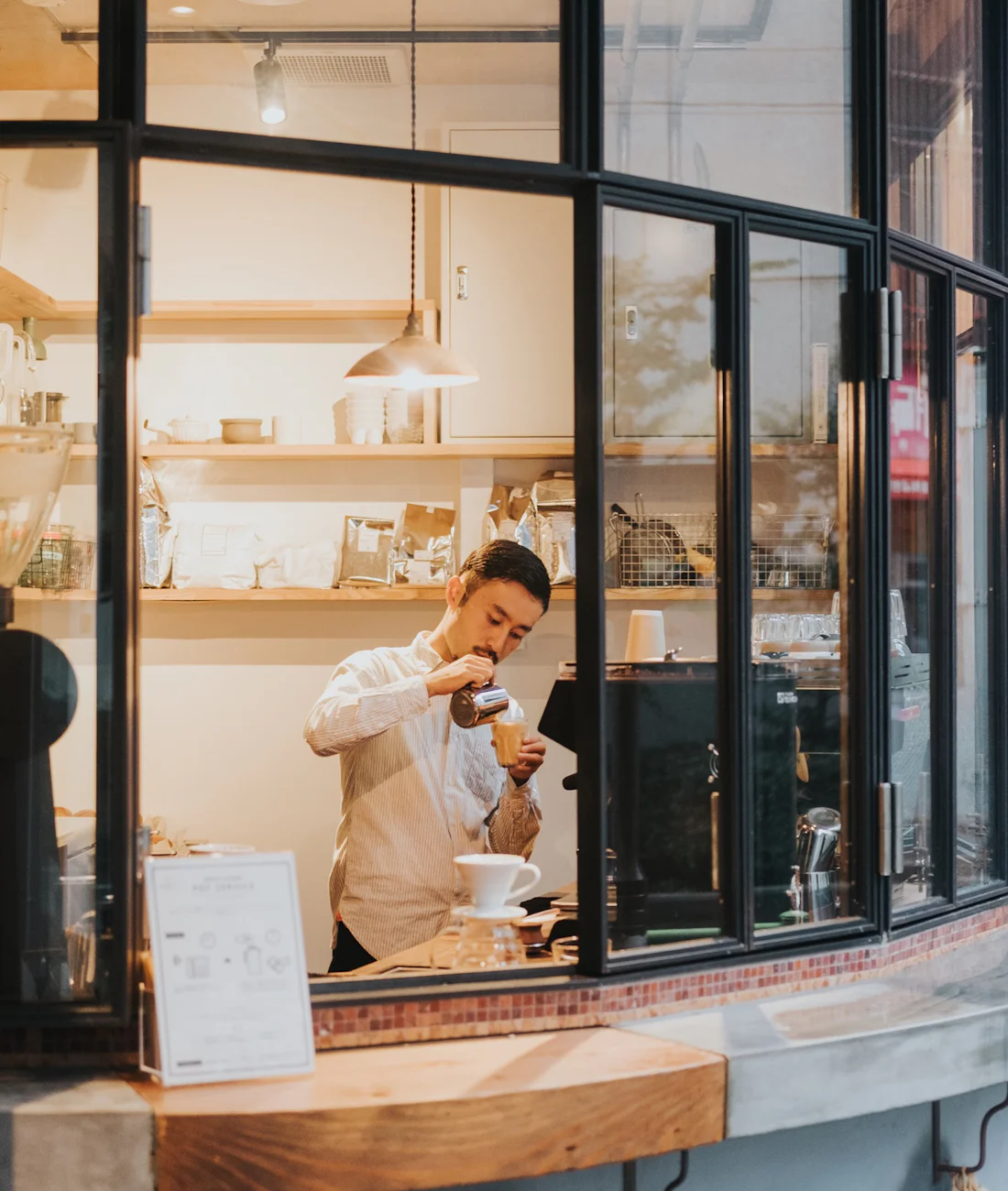 Barista preparando café em uma cafeteria, exemplo de negócio local atendido pela Venturini Digital
